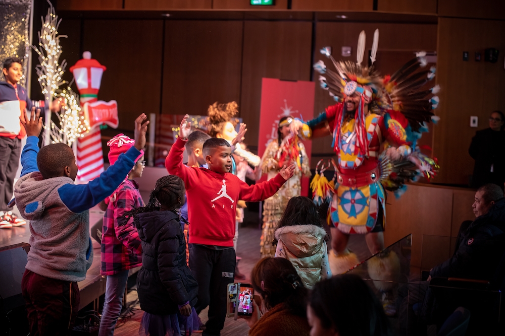Group of children dancing with aboriginal pow-wow dancer