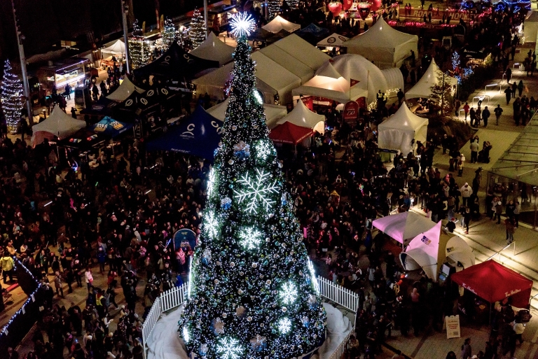 Top down view of festival crowd surrounding 60 foot Christmas tree