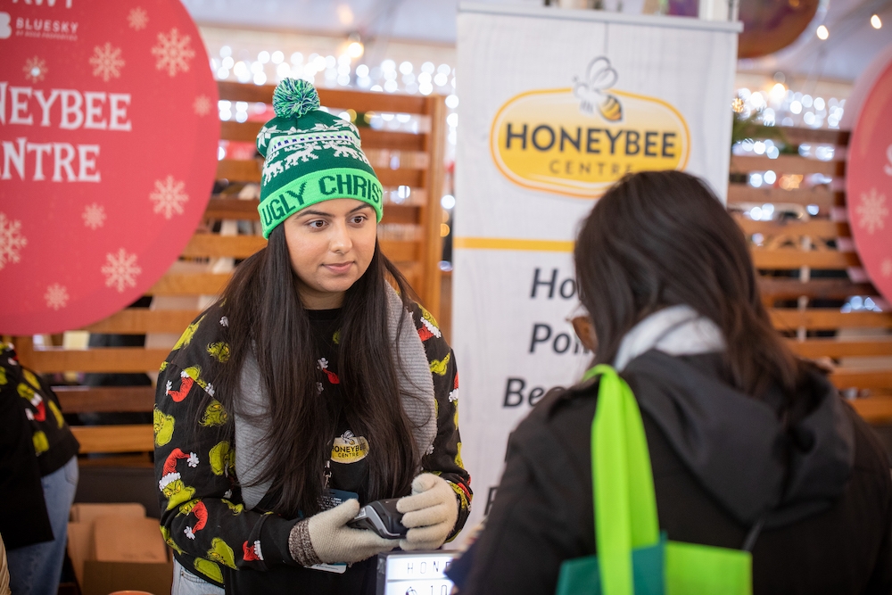 Woman makes purchase with Honeybee market vendor